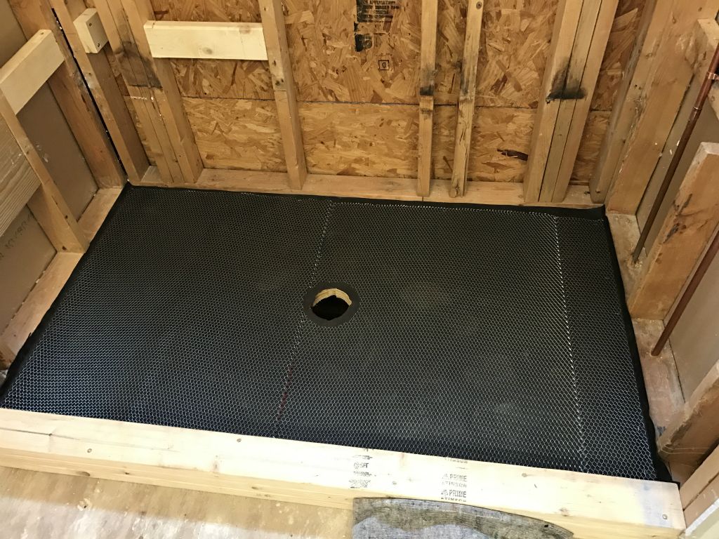 We're going to build the shower tray ourselves.  Curb in place and then first layers of tray - tar paper and metal mesh.
